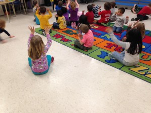 Acting out and signing a song about the life cycle of a chicken in music